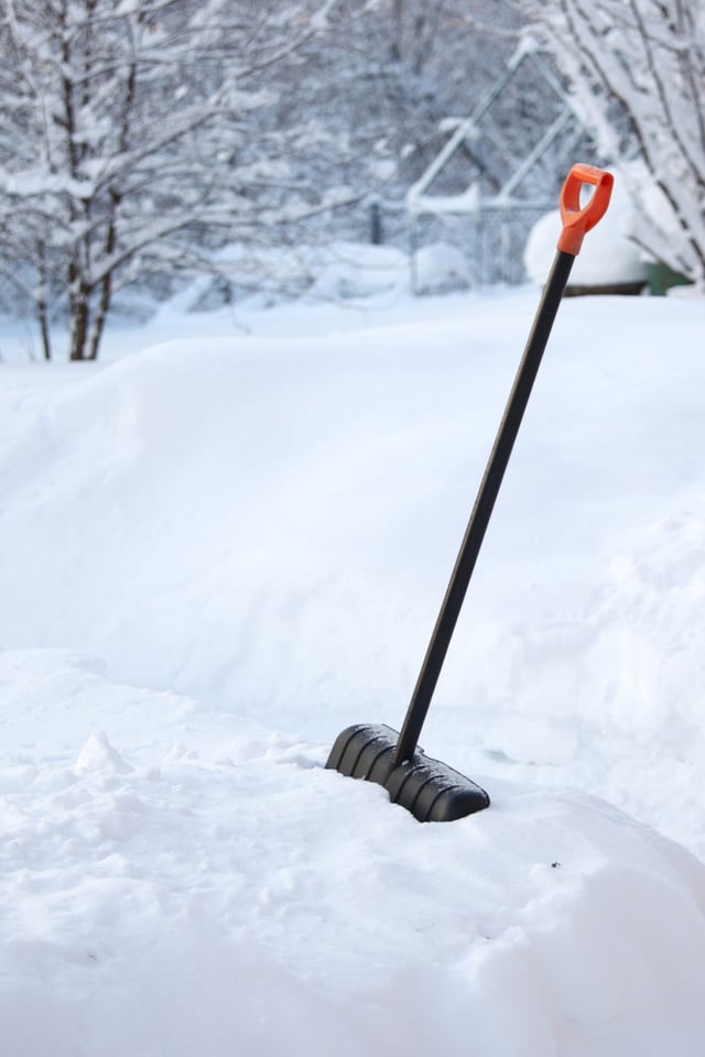 Snow shovel in deep snow bank