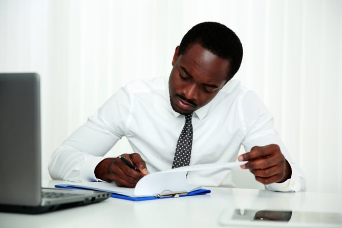 African man signing document in office-1