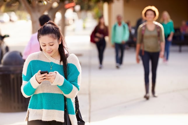 young woman on cell phone playing Pokémon Go