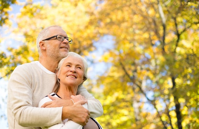 mature couple enjoying fall leaves