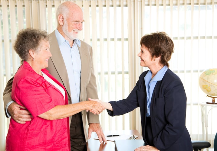 elderly couple shaking hands with personal injury lawyer