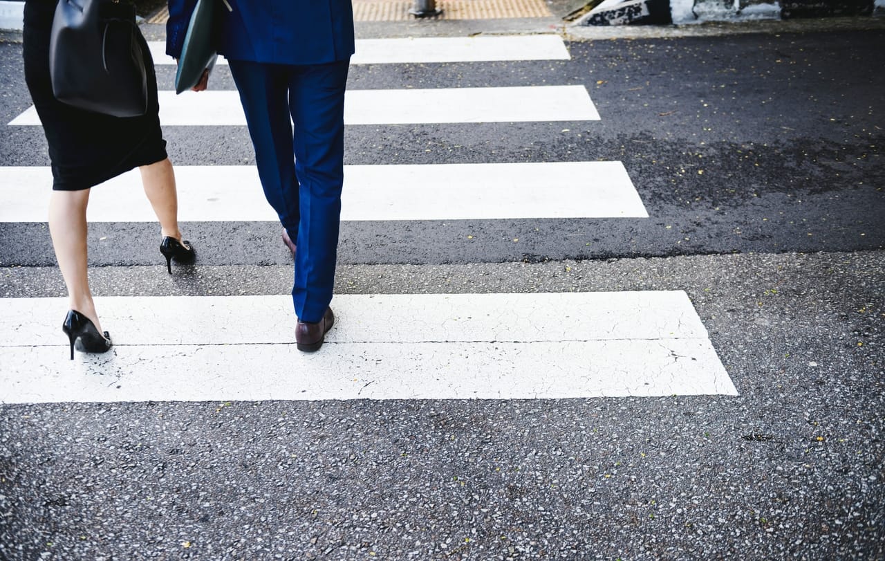man-and-woman-crossing-street-in-crosswalk