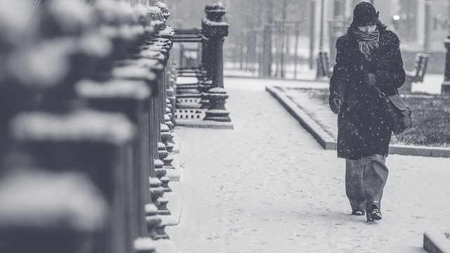 woman walking in blizzard on street