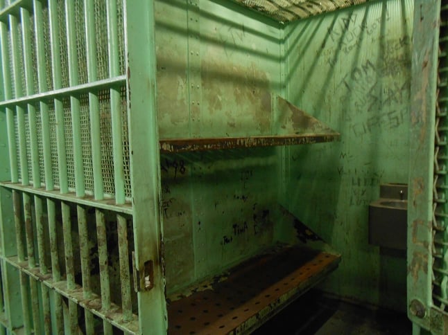 Prison or jail cell with bars and door open