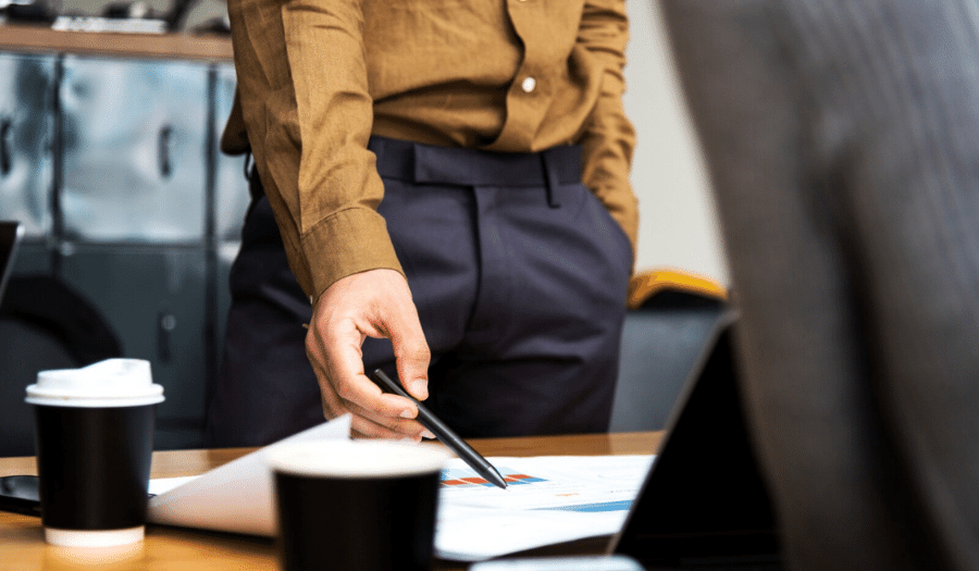 Man standing up pointing at papers on a desk
