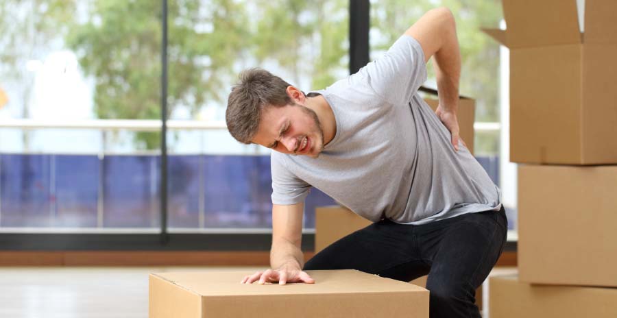 man with moving boxes experiencing back pain